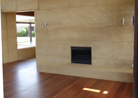 Fireplace in rammed earth wall